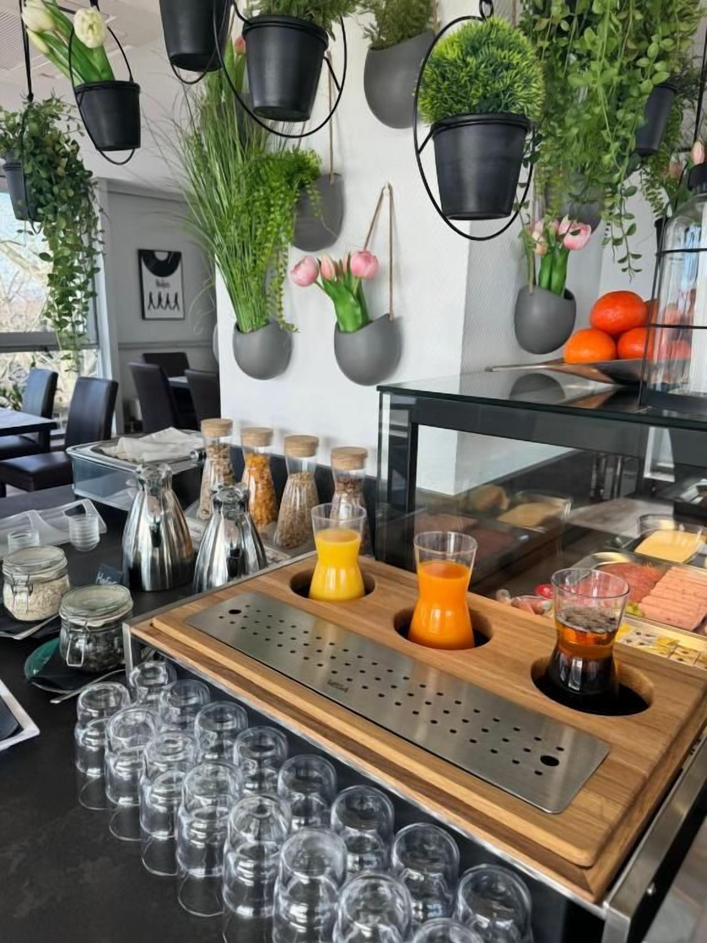 A bar area with a wooden counter, glasses, and a variety of condiments.