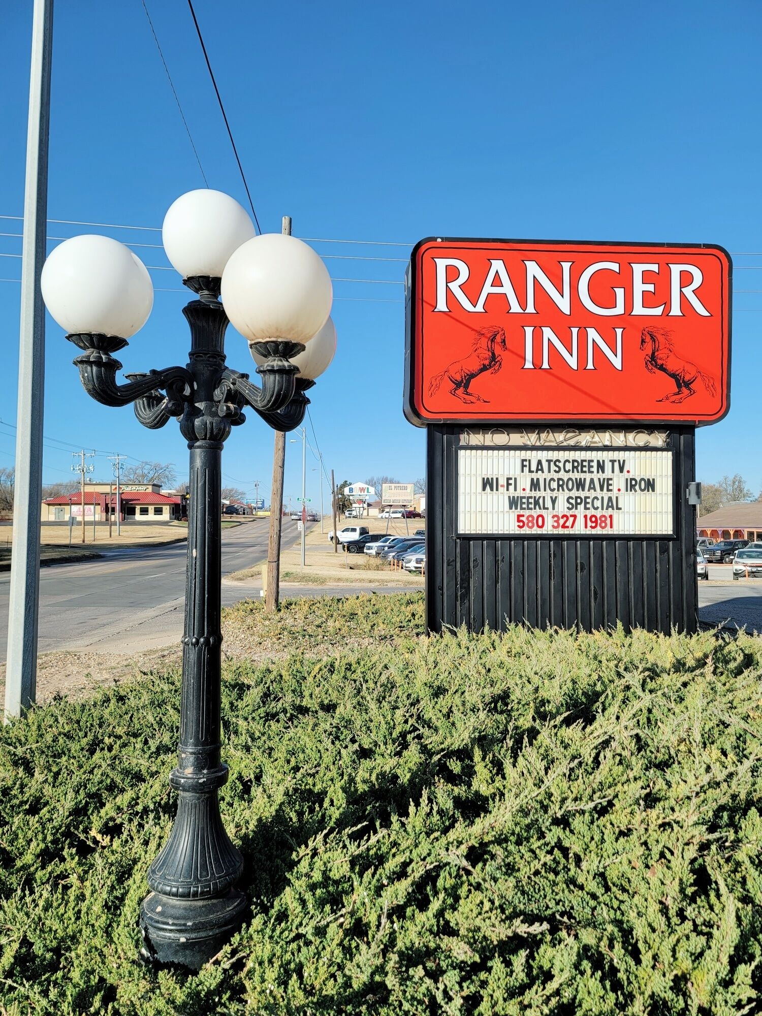 Señal del Ranger Inn con los servicios indicados, incluyendo televisión de pantalla plana, Wi-Fi, microondas y plancha.