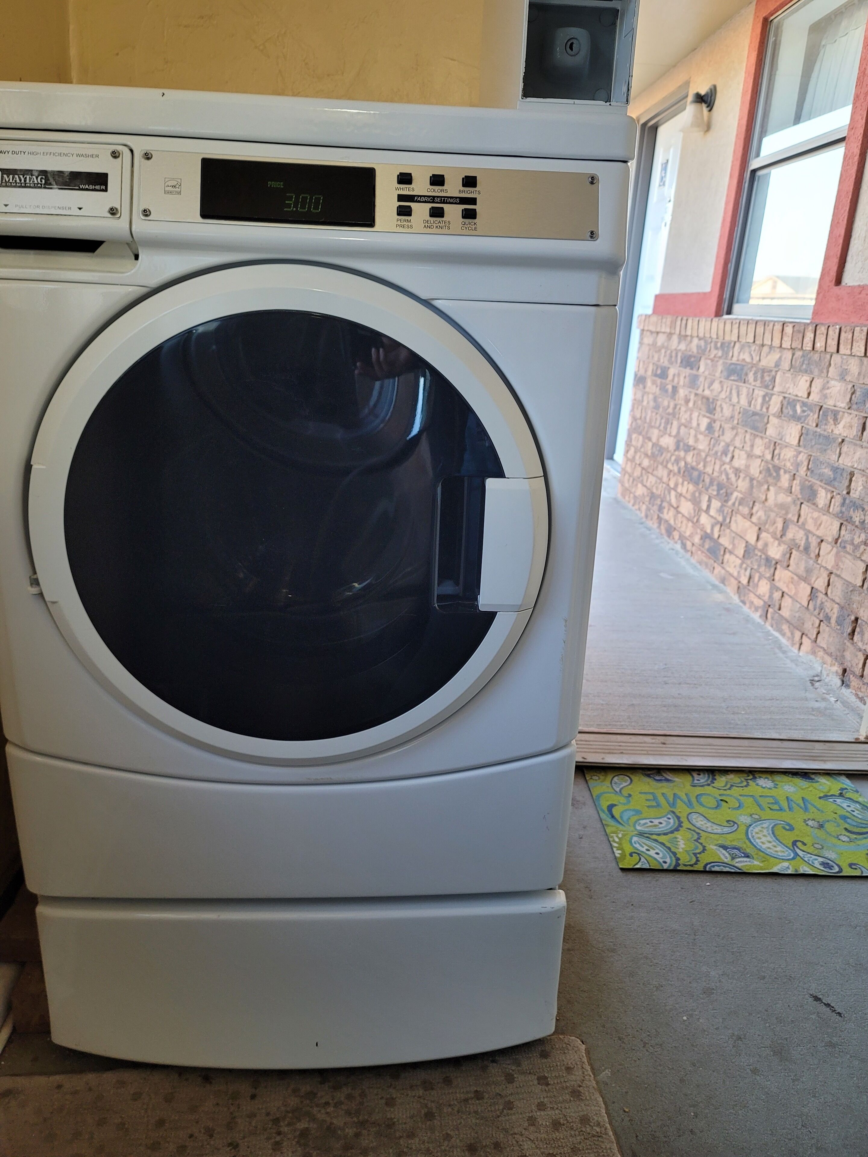 A front-loading washing machine with a digital display and control panel.