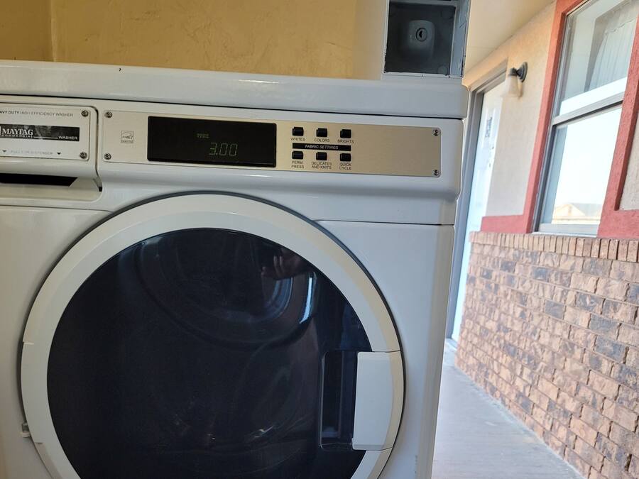 A front-loading washing machine with a digital display and control panel.