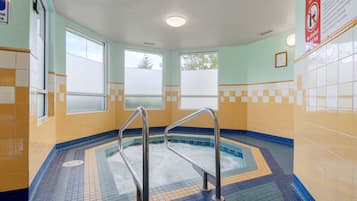 Bath area features a checkered tile floor and walls, two large windows, and a recessed light fixture.