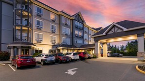 A multi-story hotel with a parking lot and a covered entrance. - Best Western Plus Chemainus Inn (Chemainus)
