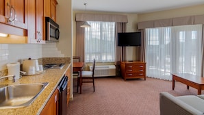 A hotel room with a kitchen area, a dining table, a TV, and a sofa. - Best Western Plus Chemainus Inn (Chemainus)