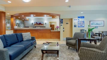 A reception area with a wooden reception desk, a blue sofa, and a coffee table.