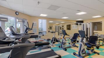 A gym with various exercise equipment, including treadmills, stationary bikes, and elliptical machines.