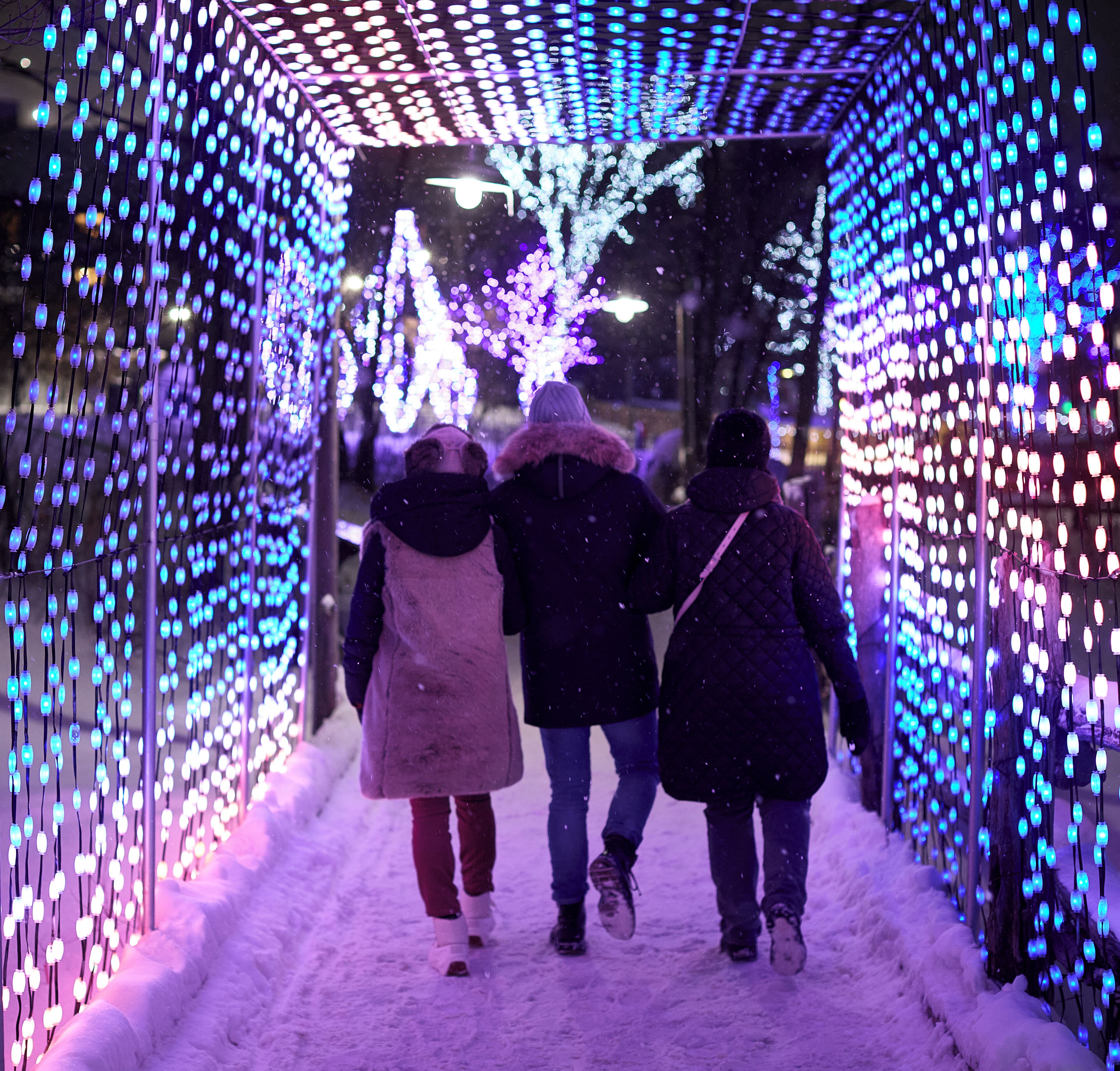 Un túnel con luces colgantes y nieve en el suelo.