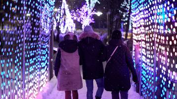 Un túnel con luces colgantes y nieve en el suelo.