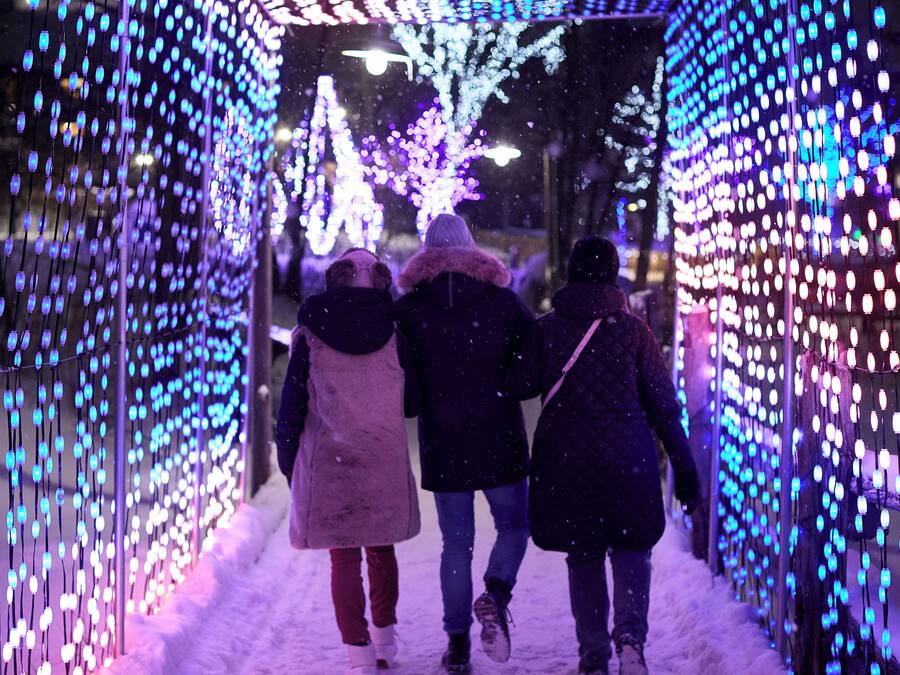 Un túnel con luces colgantes y nieve en el suelo.
