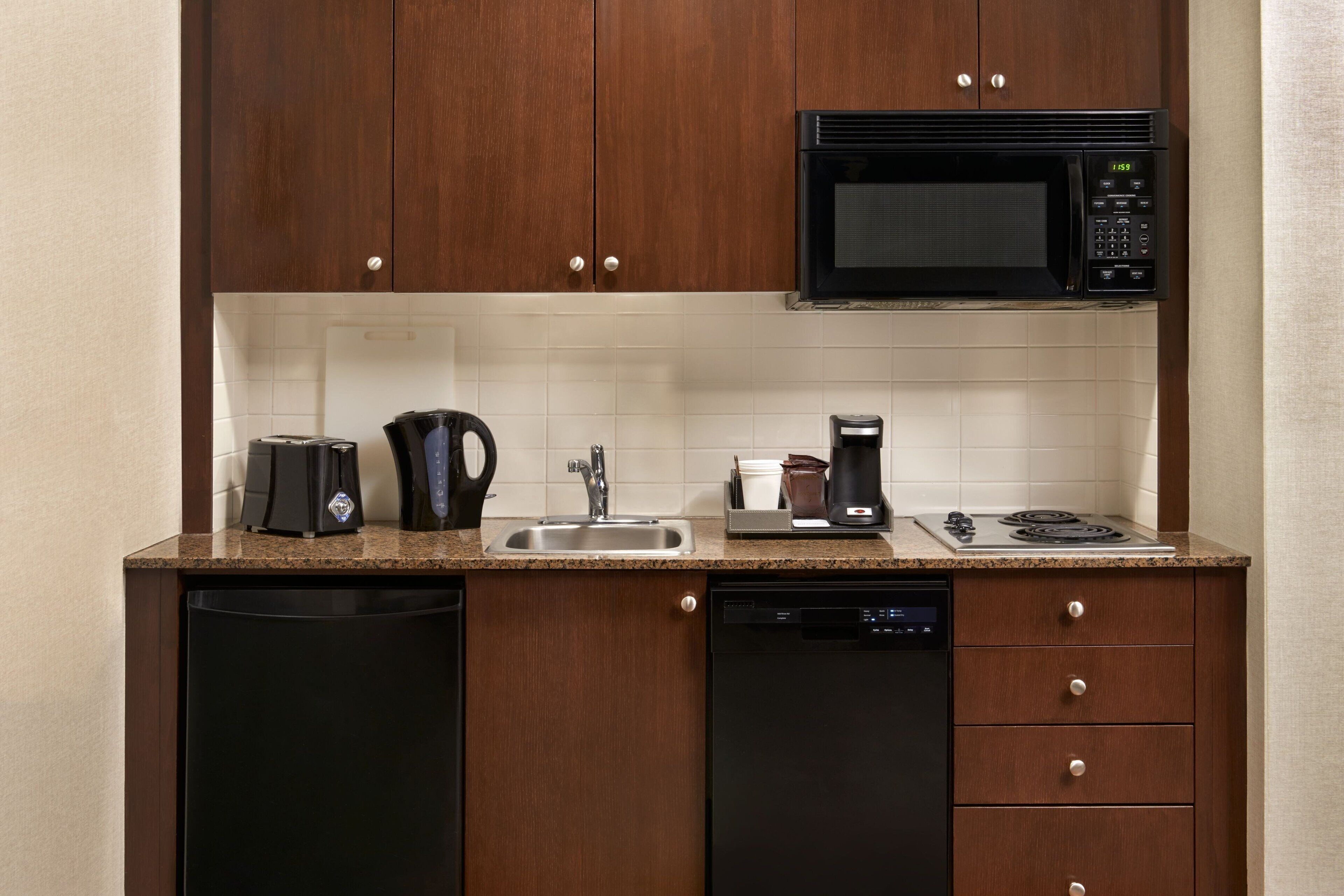 A compact kitchen with a microwave, coffee maker, and dishwasher.