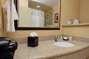 A bathroom with a sink, mirror, towel rack, and a hairdryer. - Courtyard by Marriott St George (St. George)