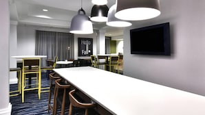 A modern hotel room with a long white table, yellow chairs, and pendant lighting. - Fairfield by Marriott Inn & Suites Richmond Innsbrook (Richmond)