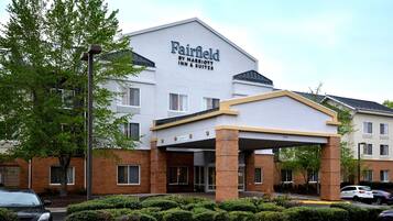 A Fairfield Inn & Suites hotel with a covered entrance, brick facade, and a parking area.