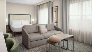 Une chambre d’hôtel avec un lit, un canapé, une petite table et une chaise.