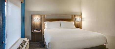 Een hotelkamer met een bed, nachtkastjes, een verwarming en wandlampen.