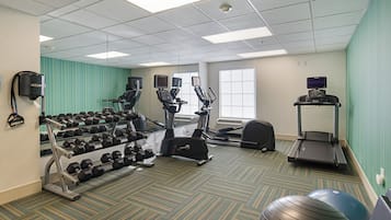 Un centre de remise en forme équipé de tapis de course, de vélos elliptiques et de poids libres.