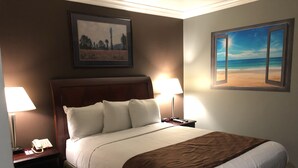A hotel room with a large bed, two bedside tables with lamps, a phone, and a painting above the bed. - Knights Inn Downtown Los Angeles (Los Angeles)