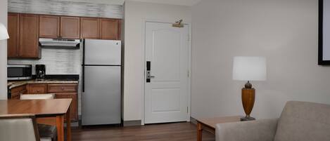 A compact living space with a kitchenette, a dining area, and a seating area.
