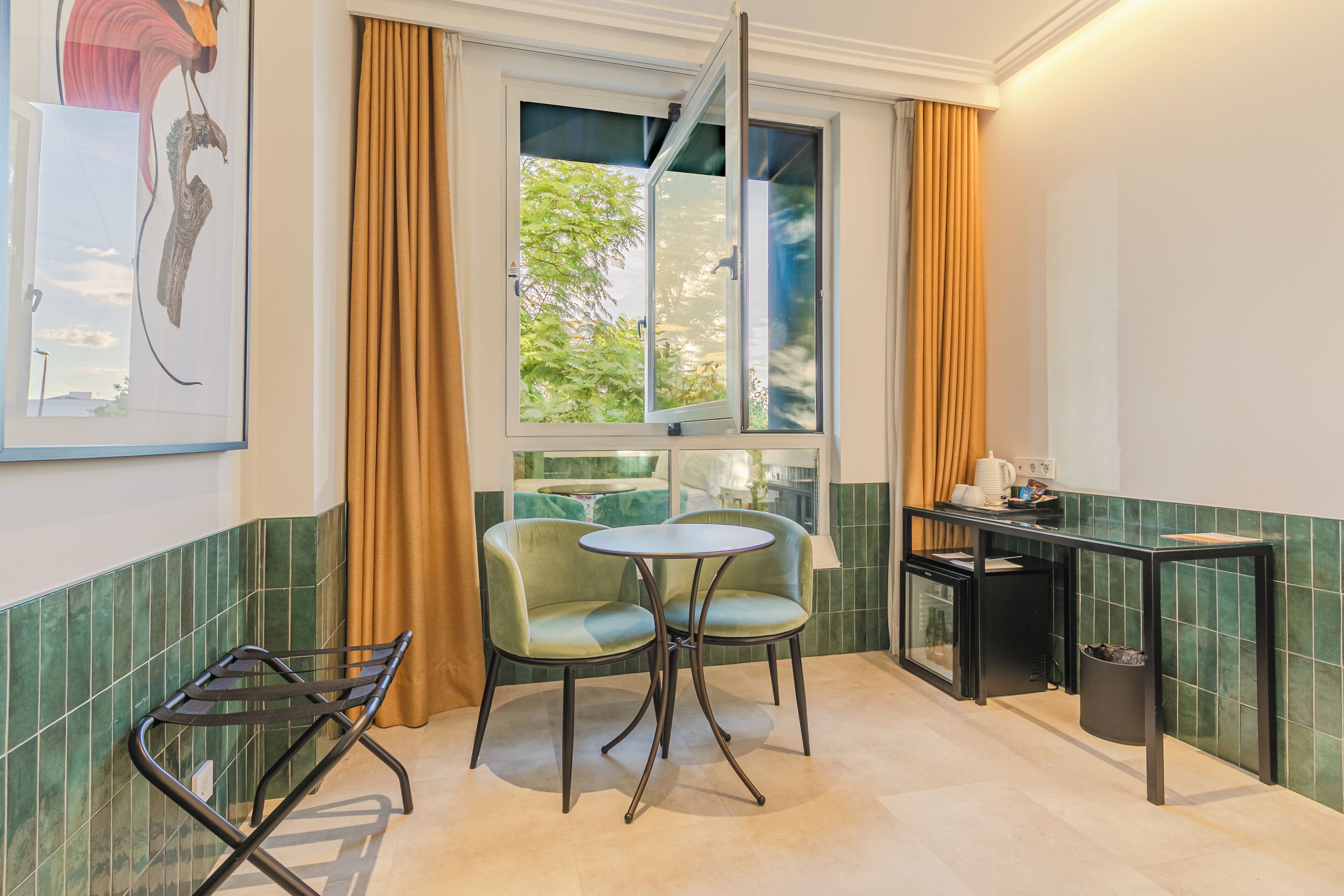 A small kitchen with a dining area, a window with curtains, and a green tiled backsplash.