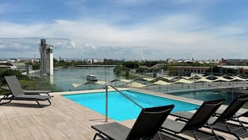 Una piscina al aire libre de temporada, tumbonas