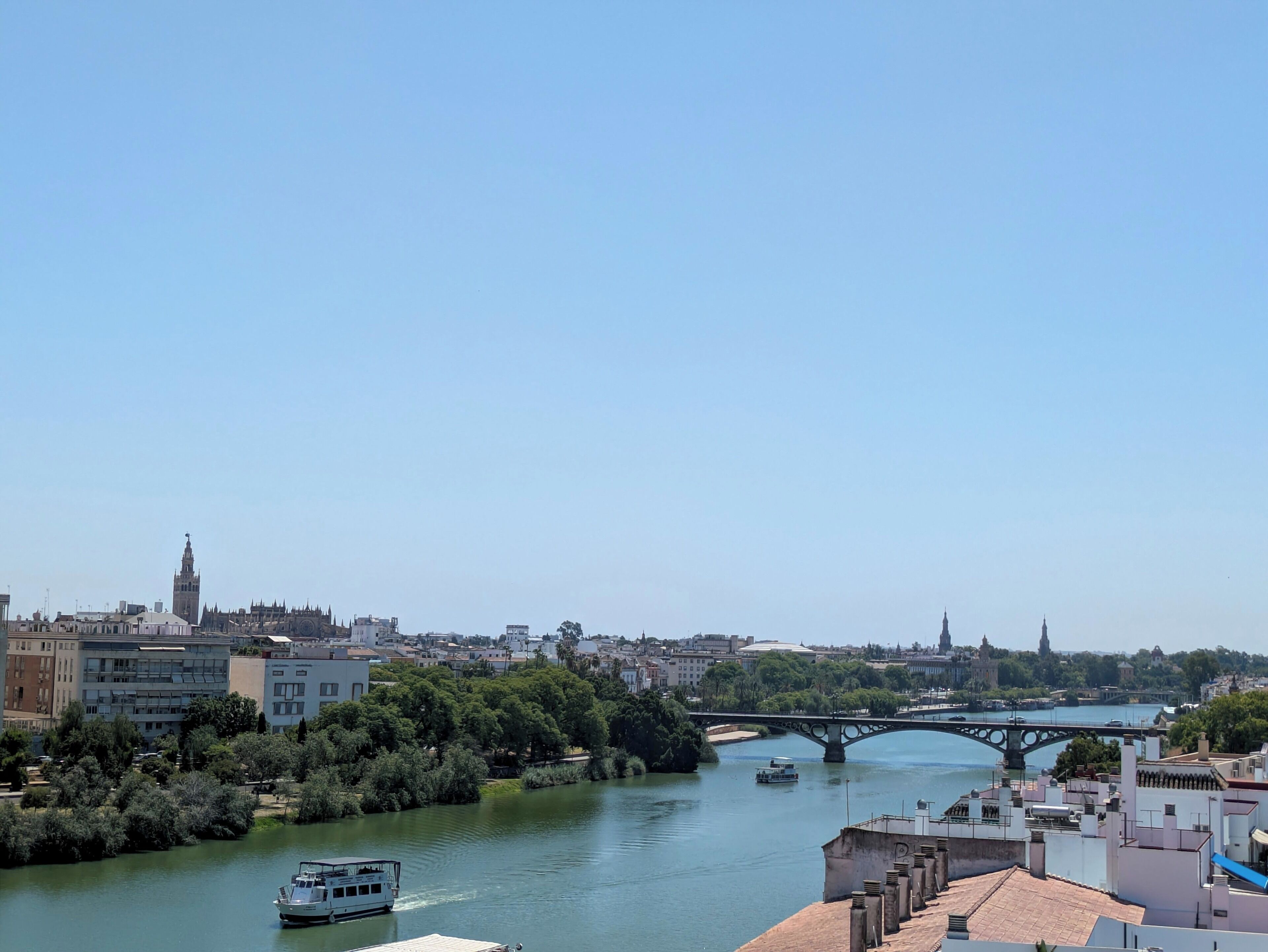 Un río con barcos, un puente y edificios a lo largo de la orilla.