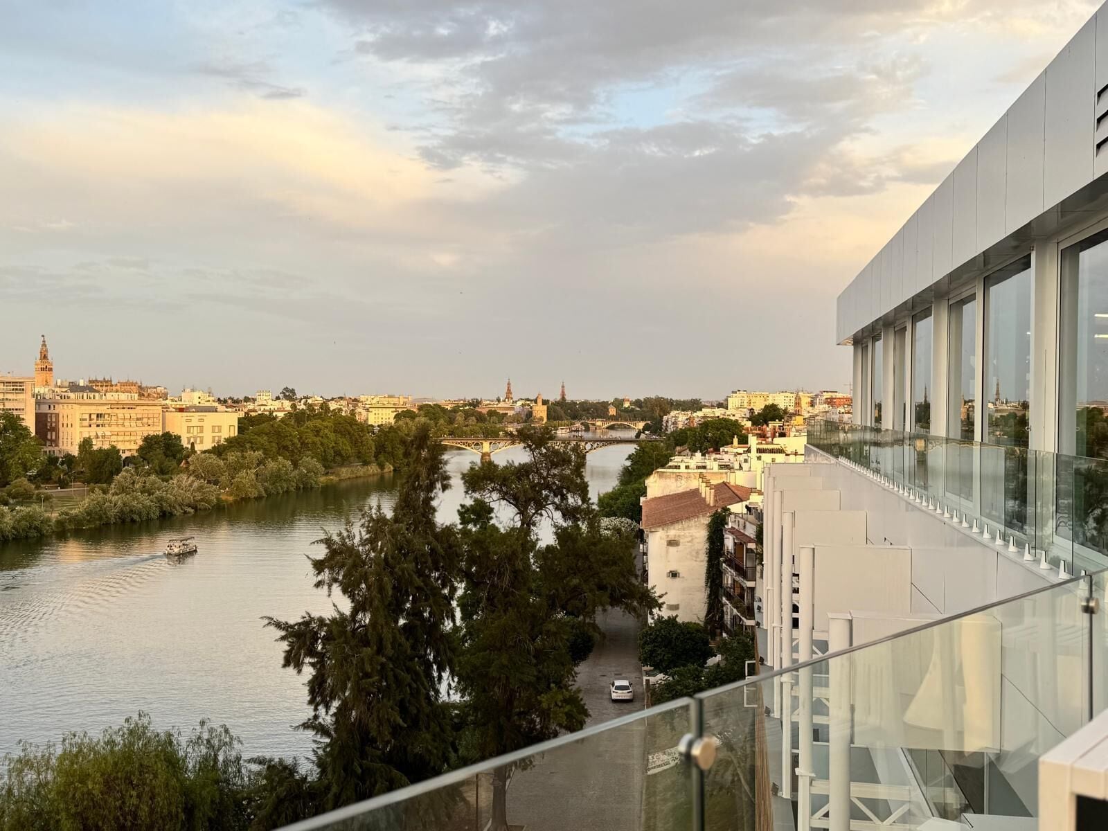 A river with a bridge, buildings, and trees.