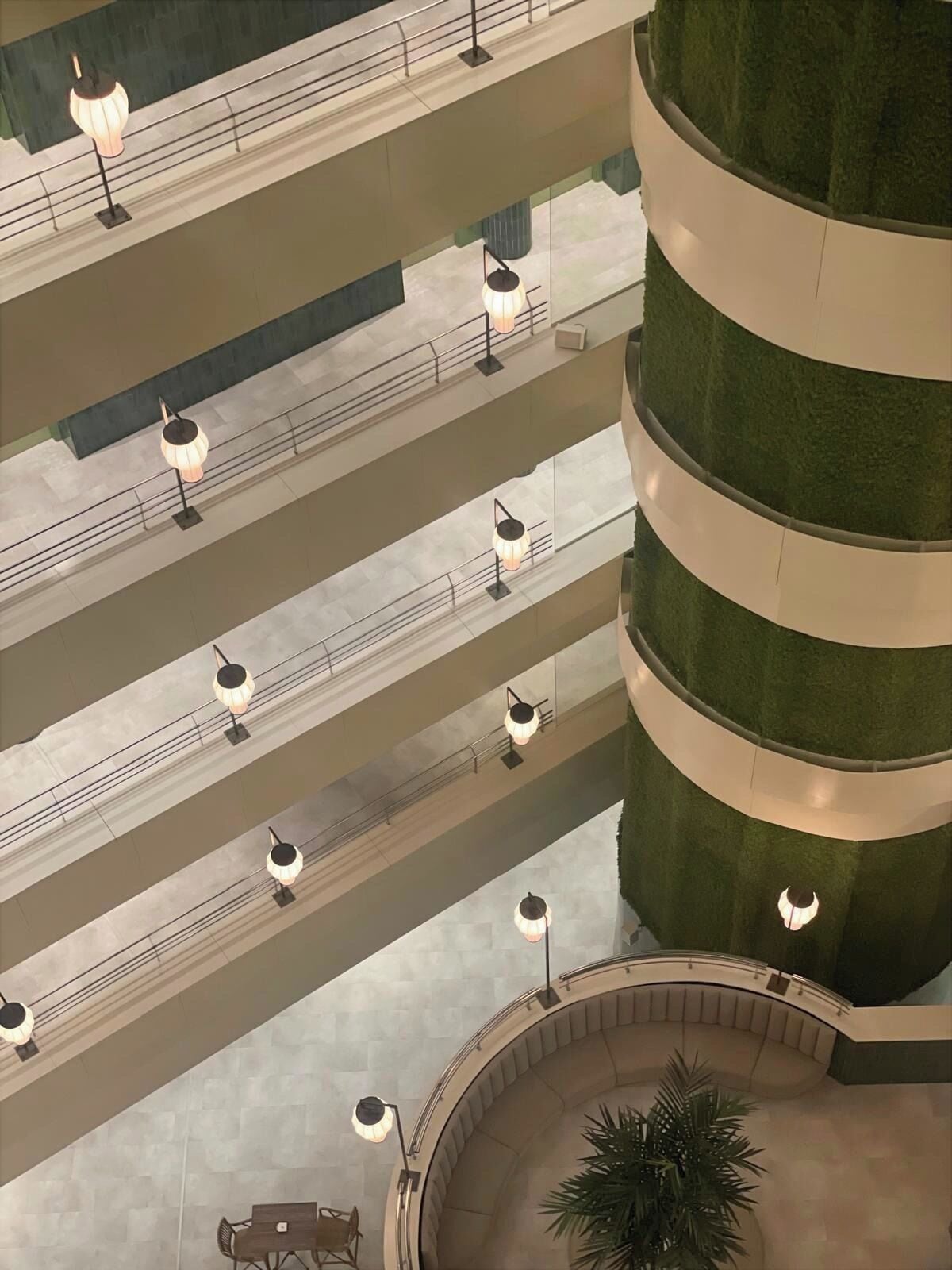 A multi-level atrium with a central circular seating area and multiple floors connected by a central column.