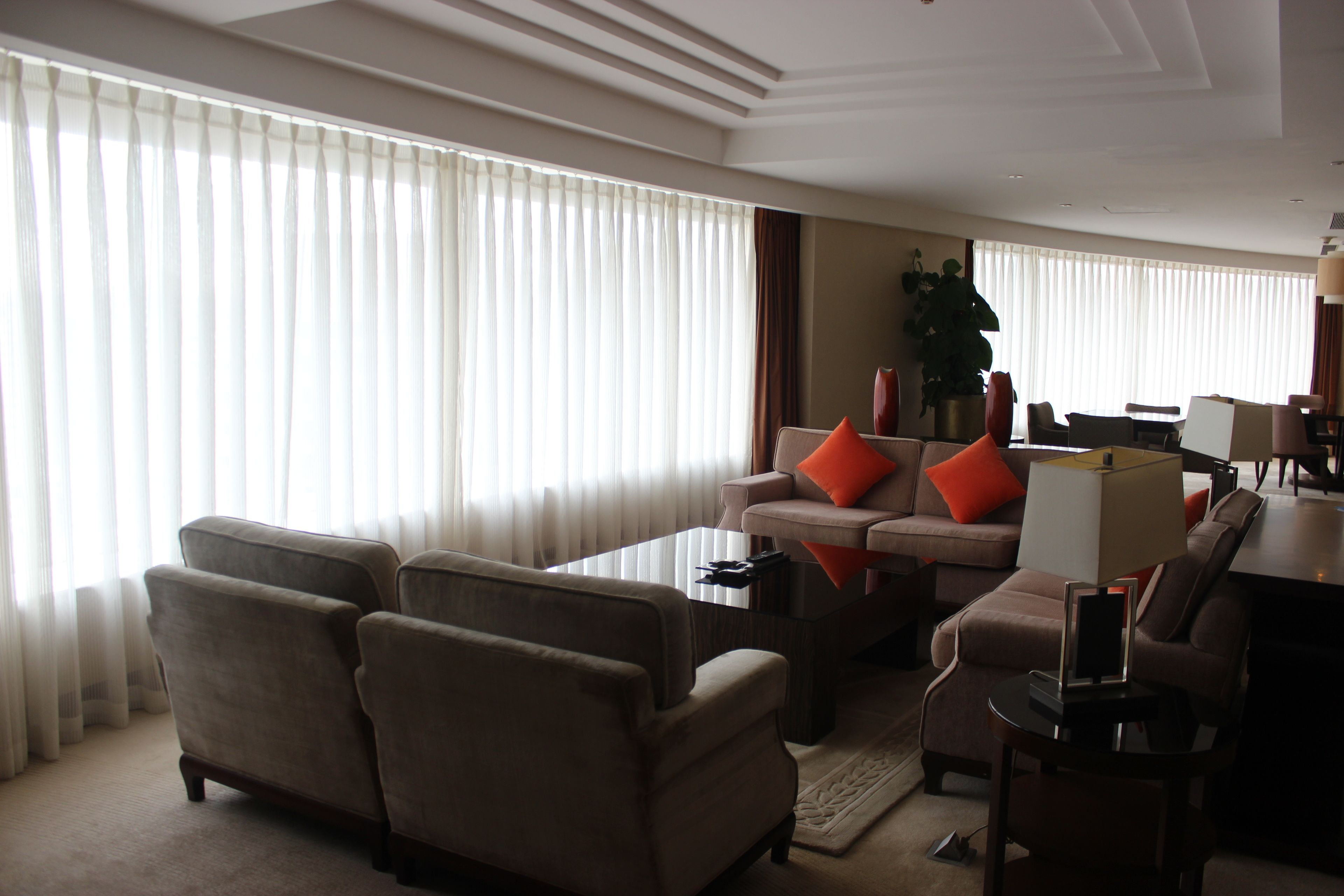 A modern living room with a sofa, armchairs, a coffee table, and a dining area.