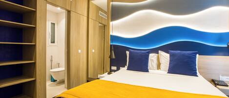 A hotel room with a bed, a bathroom, and a wardrobe.