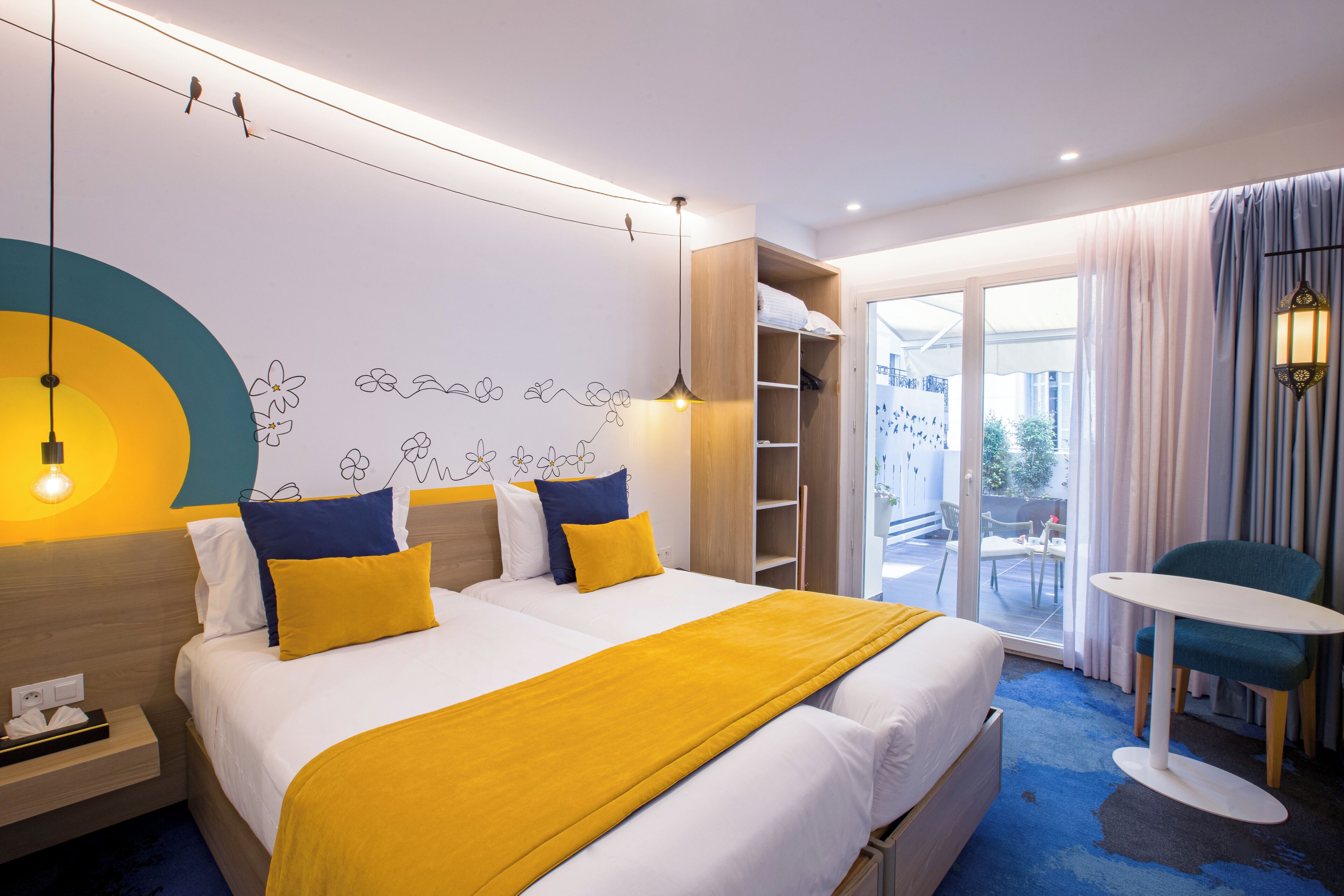 A hotel room with a large bed, a desk with a lamp, a chair, and a view of the outside.
