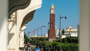 A busy urban street with a prominent clock tower in the background.