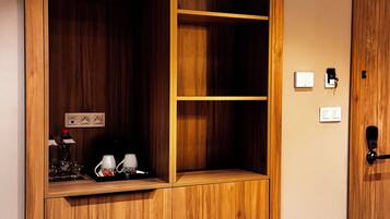 Un mueble de madera con varios estantes y una encimera con una cafetera y otros objetos.