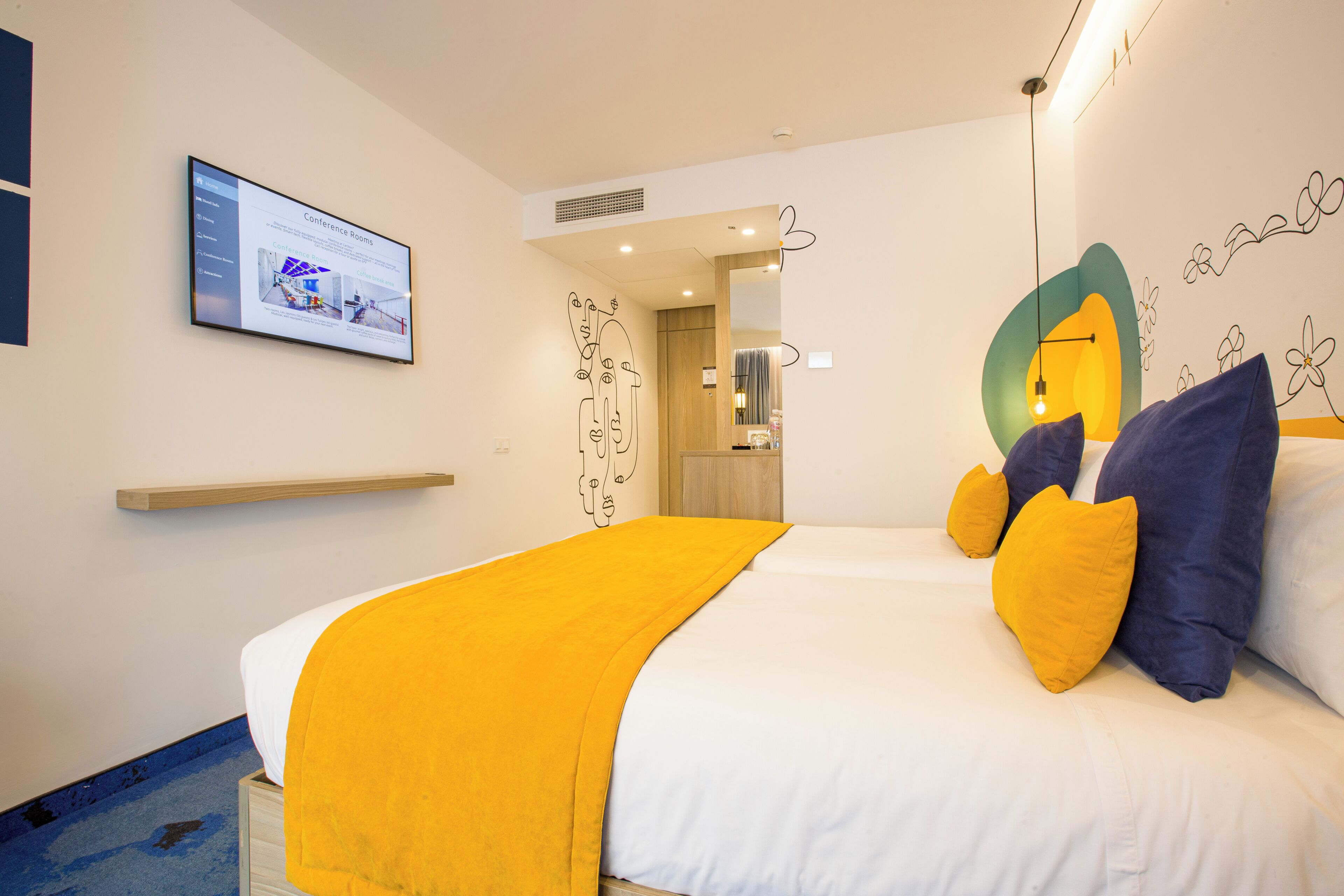 A hotel room with a bed, a mounted TV, and a mirror.