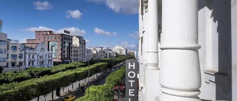 Un hotel con un llamativo letrero que dice 'HOTEL' en un pilar, rodeado de edificios urbanos y un cielo despejado.