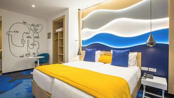 A modern hotel room with a bed, bedside table, and a wall with a wavy pattern.