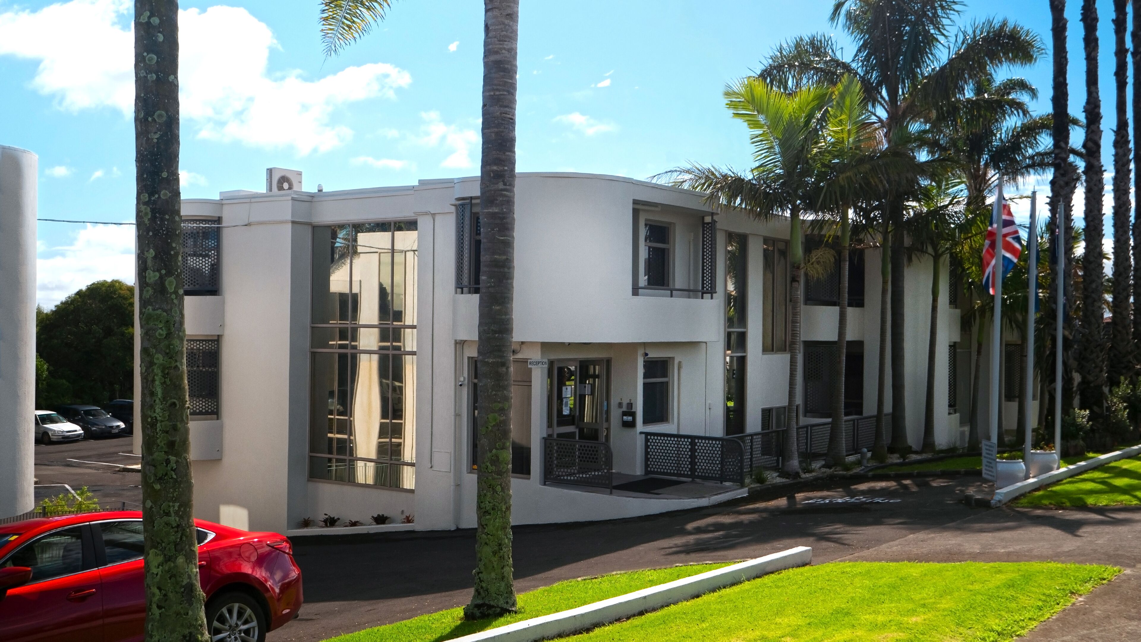 A modern building with a reception area, large windows, and a flag.