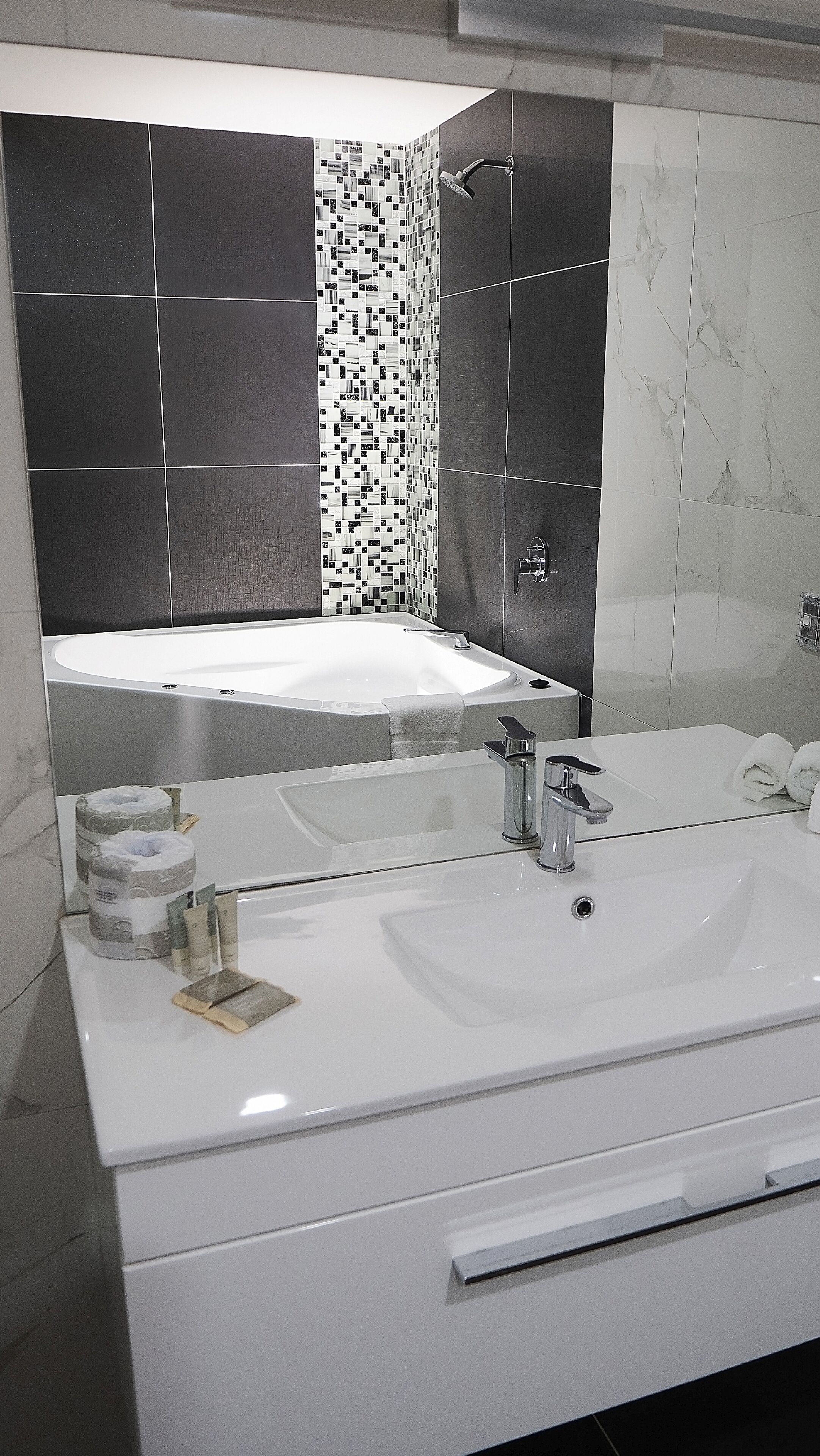 Un baño moderno con un lavamanos grande de color blanco, una bañera y una ducha.