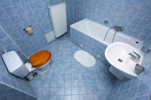 A bathroom with a toilet, bathtub, and sink.