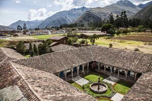 A courtyard with a tiled roof, a central fountain, and surrounding buildings. - Boutique San Agustín Monasterio de la Recoleta (Urubamba)