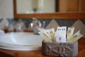 A stone basin with toiletries on a countertop in a bathroom. - Boutique San Agustín Monasterio de la Recoleta (Urubamba)