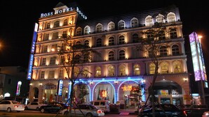 Un hotel de varios pisos con un cartel llamativo que dice "Boss Hotel Boss".