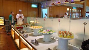 A buffet area with various food stations, including a salad bar and a dessert display. - Chuto Plaza Hotel (Taoyuan City)