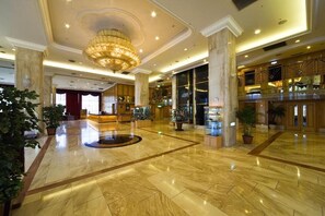 A spacious lobby with marble flooring, a grand chandelier, and a reception area. - Chuto Plaza Hotel (Taoyuan City)