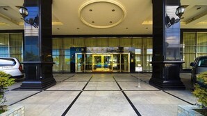 A hotel entrance with a glass facade, black columns, and a circular ceiling design. - Chuto Plaza Hotel (Taoyuan City)