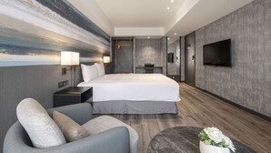 A modern hotel room with a large bed, a sofa, a TV, and a wall art piece. - Lakeshore Hotel Metropolis (Hsinchu)