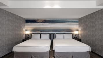 A double room with two beds, a large abstract painting on the wall, and a wooden floor.