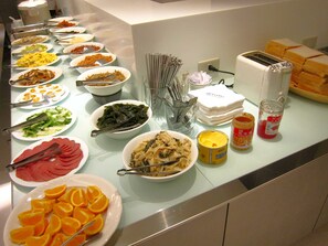 Enjoy a diverse spread of international cuisine at our buffet, featuring a variety of dishes and condiments.