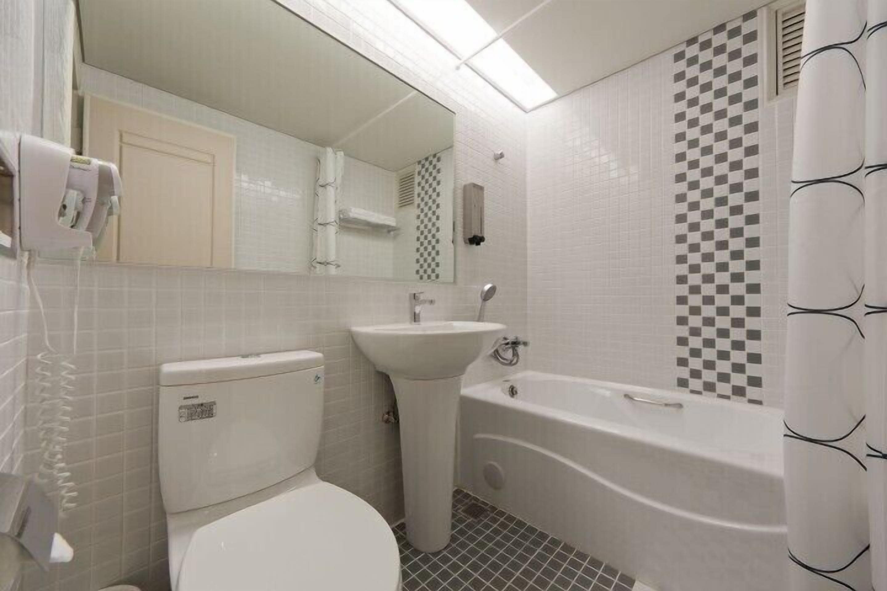 A bathroom with a toilet, sink, and bathtub.