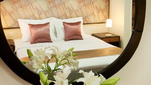 A hotel room with a bed, nightstand, lamp, and a mirror. - Beijing HWA Apartment Hotel (Beijing)