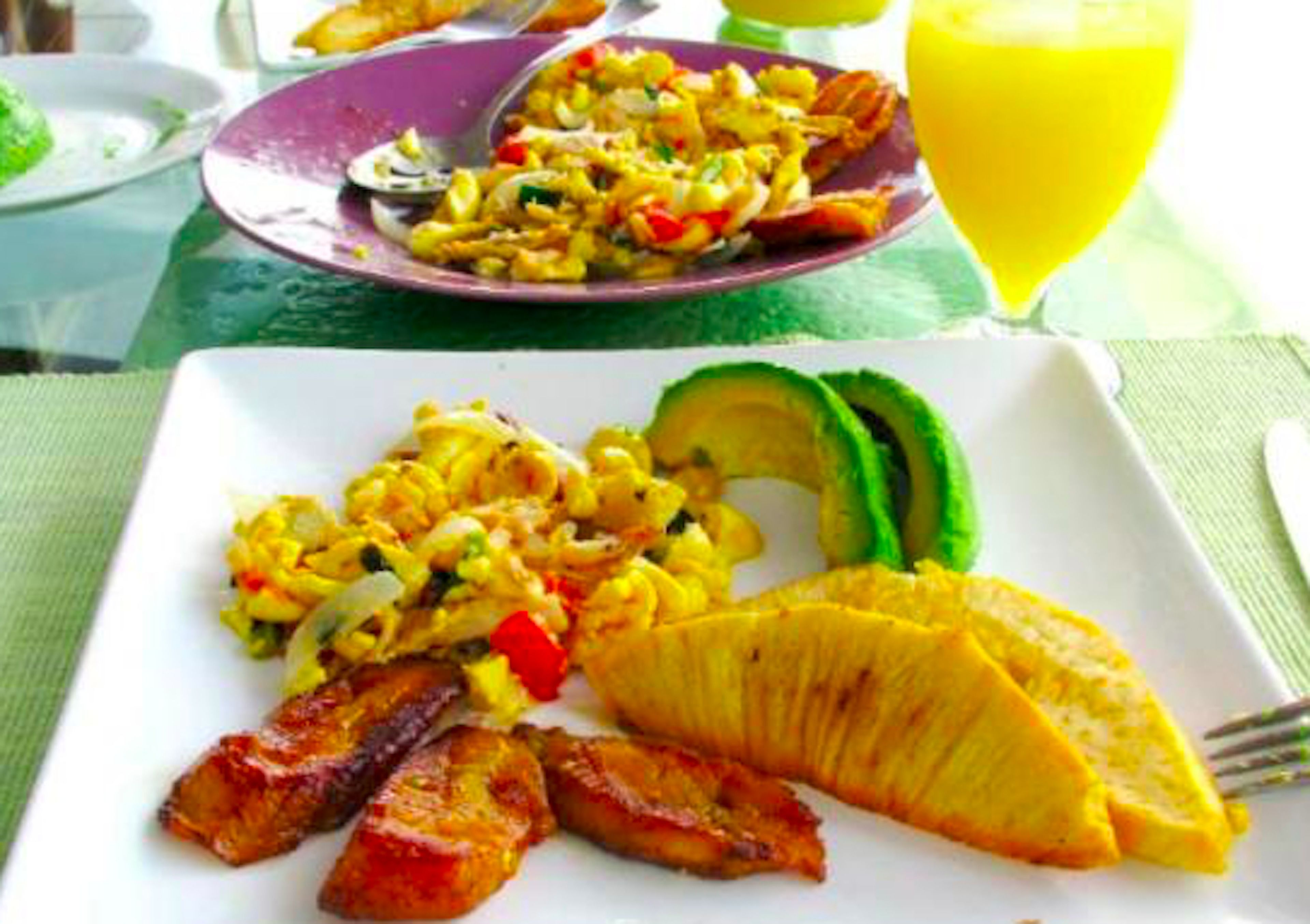 A breakfast plate with eggs, avocado, and bacon.