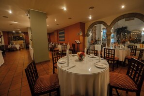 A restaurant with round tables, chairs, and a tiled floor. - Hotel San Agustin El Dorado (Cusco)